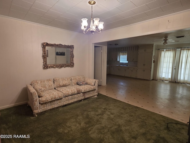 unfurnished living room featuring carpet flooring and ceiling fan with notable chandelier