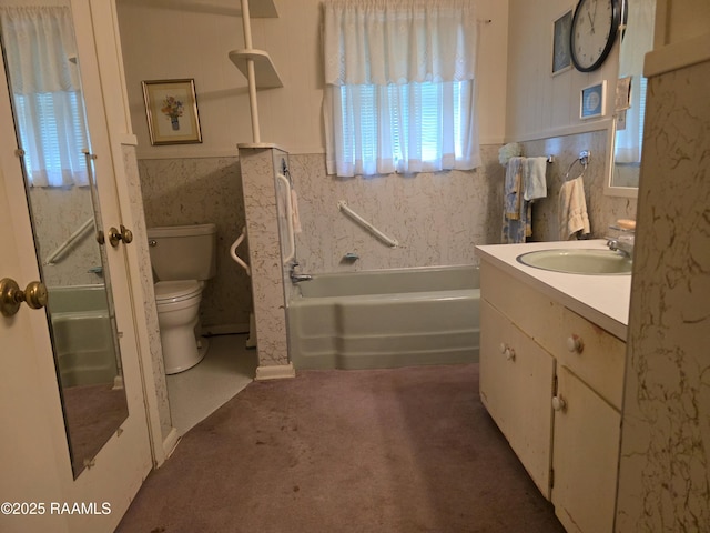 bathroom with a tub, toilet, wainscoting, vanity, and a shower