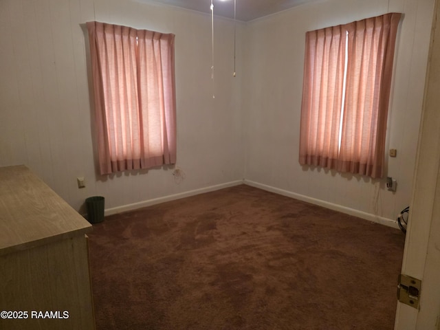 empty room featuring carpet and baseboards