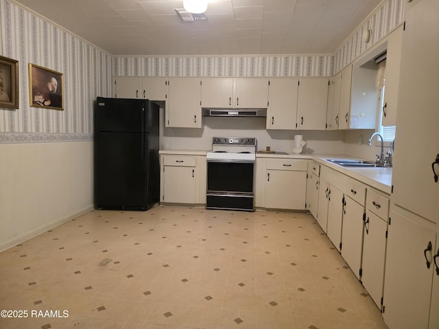 kitchen featuring wallpapered walls, a wainscoted wall, freestanding refrigerator, electric stove, and a sink