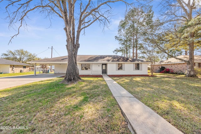 ranch-style home featuring an attached carport, driveway, and a front lawn