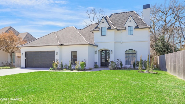 french provincial home featuring driveway, a front lawn, fence, french doors, and an attached garage