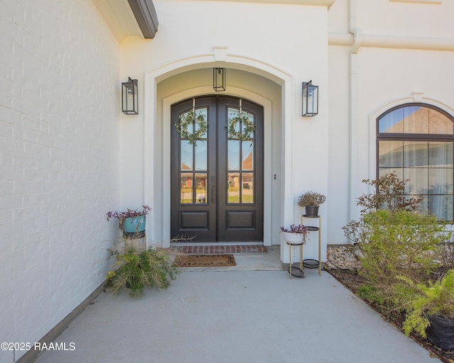 entrance to property with french doors and stucco siding