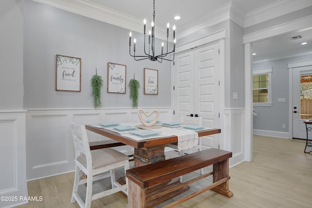 dining space with recessed lighting, a notable chandelier, light wood-style flooring, and crown molding