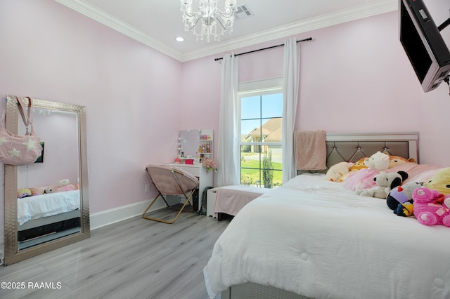 bedroom featuring visible vents, wood finished floors, crown molding, baseboards, and a chandelier