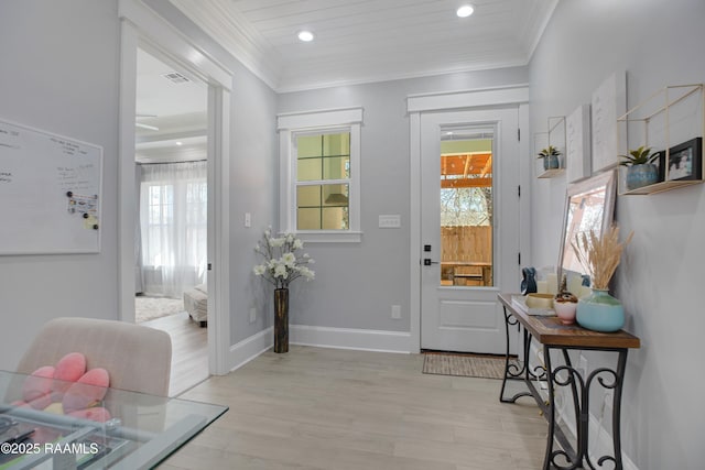 foyer featuring a wealth of natural light, visible vents, and crown molding