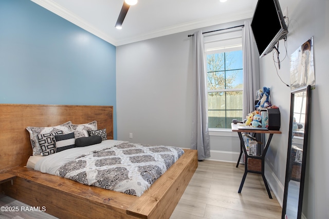 bedroom with a ceiling fan, crown molding, baseboards, and wood finished floors