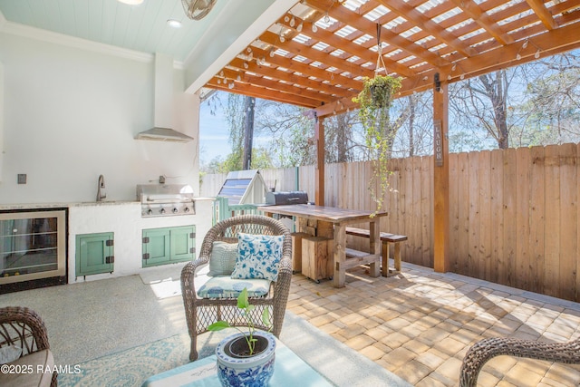 view of patio / terrace featuring area for grilling, a sink, fence, wine cooler, and outdoor dining area