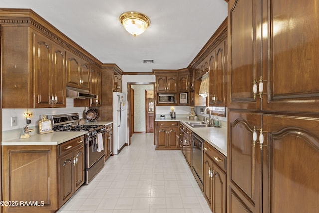 kitchen featuring visible vents, a sink, stainless steel appliances, light countertops, and under cabinet range hood