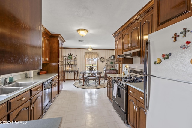 kitchen with stainless steel gas range, freestanding refrigerator, a sink, under cabinet range hood, and dishwasher