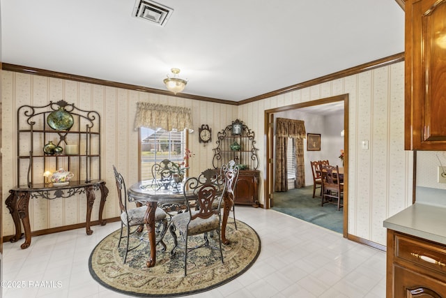 dining space with wallpapered walls, crown molding, light floors, and baseboards