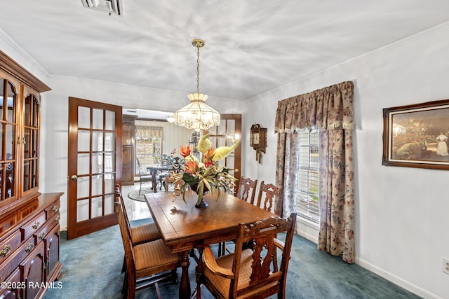 dining space with visible vents, baseboards, dark carpet, ornamental molding, and an inviting chandelier