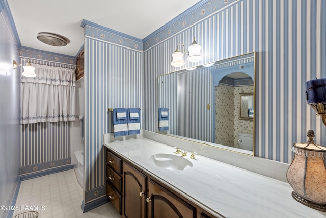 bathroom with shower / bath combo with shower curtain, toilet, vanity, and wallpapered walls