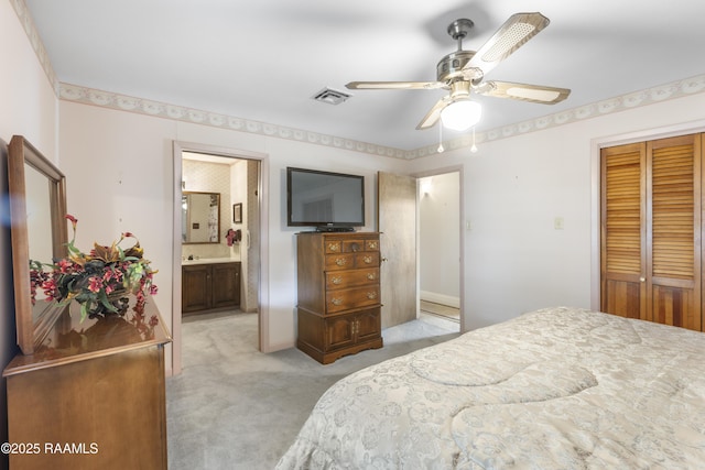 bedroom with a ceiling fan, visible vents, a closet, light colored carpet, and connected bathroom