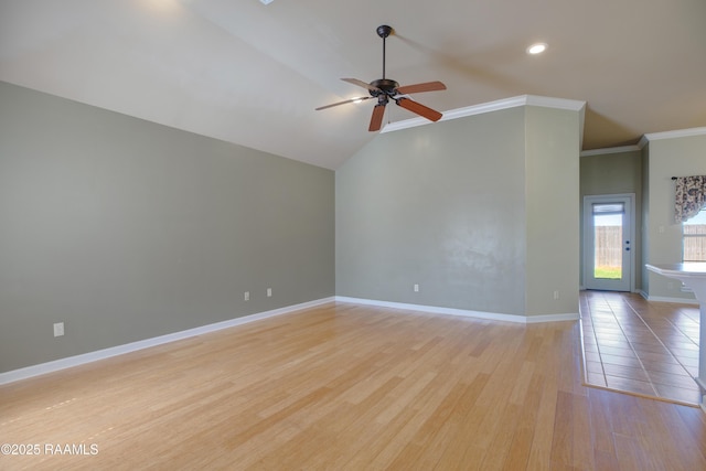 empty room featuring crown molding, baseboards, vaulted ceiling, light wood-style floors, and a ceiling fan