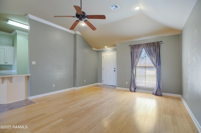 unfurnished living room featuring visible vents, baseboards, lofted ceiling, ornamental molding, and light wood-style flooring