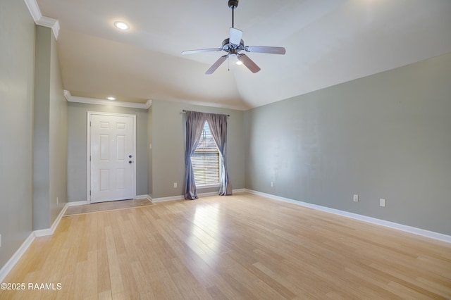 spare room featuring baseboards, lofted ceiling, a ceiling fan, and light wood finished floors