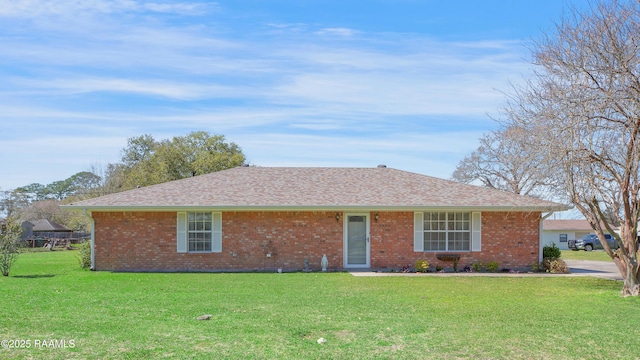 ranch-style home with brick siding, a front lawn, and a shingled roof