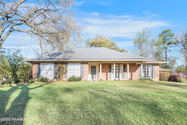 ranch-style house with a front lawn, brick siding, and roof with shingles