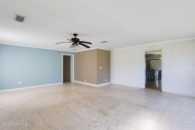 unfurnished room featuring visible vents, brick wall, speckled floor, and baseboards