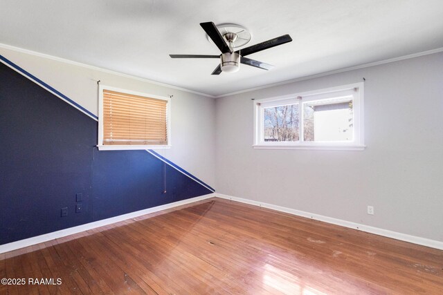 spare room with baseboards, wood-type flooring, and ornamental molding