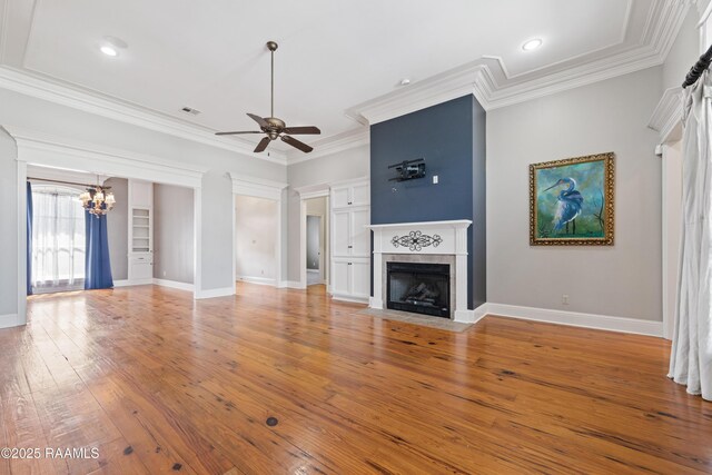 unfurnished living room with a fireplace with flush hearth, ceiling fan with notable chandelier, crown molding, and light wood finished floors