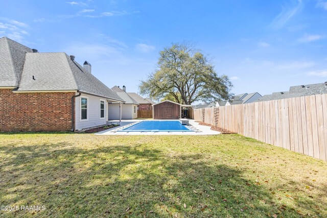 exterior space featuring a patio, a fenced in pool, a shed, a fenced backyard, and an outdoor structure