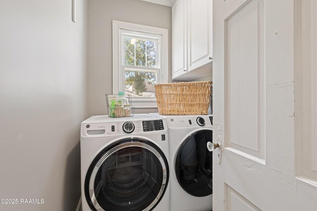 clothes washing area with cabinet space and washing machine and dryer