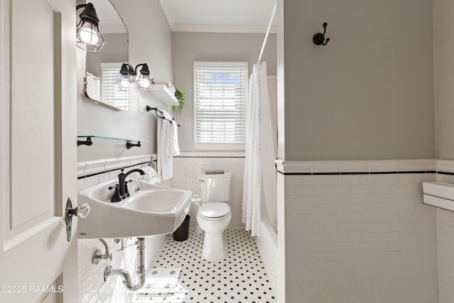 full bathroom with a wainscoted wall, a sink, ornamental molding, curtained shower, and toilet