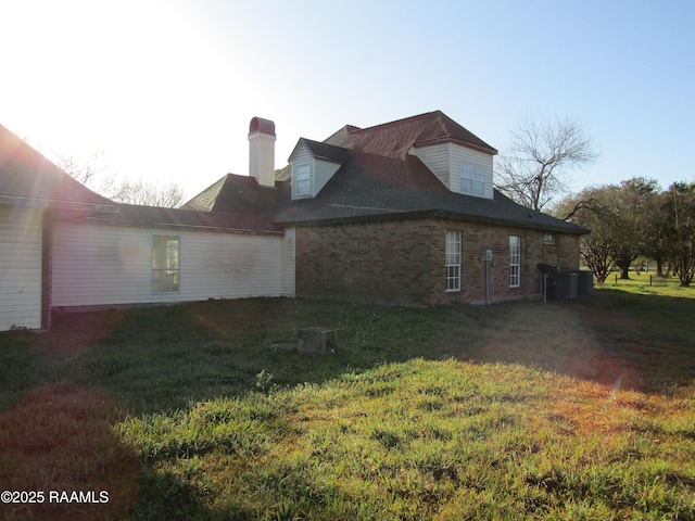 view of home's exterior featuring a yard and brick siding