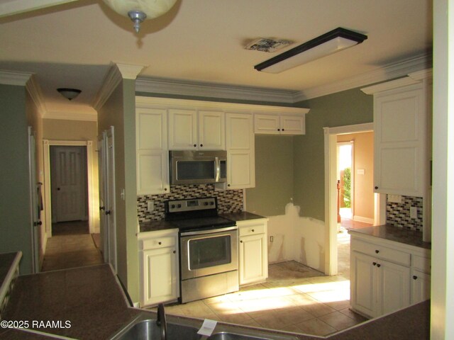 kitchen with crown molding, dark countertops, and stainless steel appliances