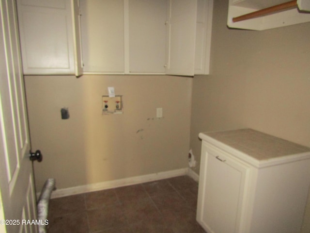 laundry room with baseboards, dark tile patterned floors, hookup for a washing machine, cabinet space, and electric dryer hookup