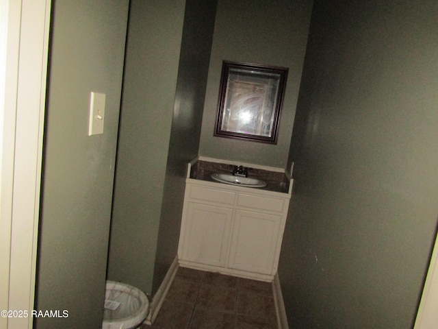 bathroom with vanity, toilet, baseboards, and tile patterned flooring