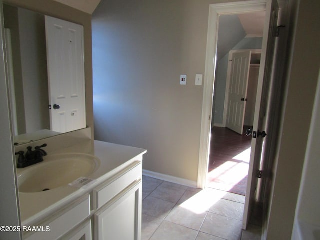 bathroom with tile patterned floors, baseboards, and vanity