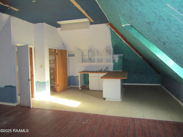 interior space with a sink, lofted ceiling, and wood finished floors