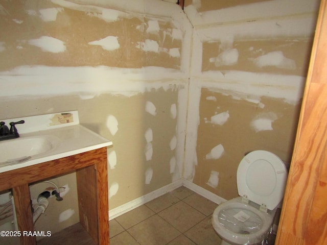 bathroom with baseboards, toilet, vanity, and tile patterned flooring