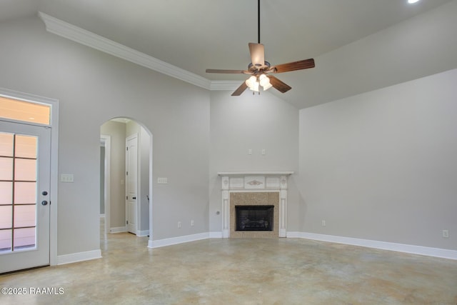 unfurnished living room featuring baseboards, concrete floors, a fireplace, arched walkways, and ceiling fan