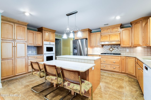 kitchen featuring decorative backsplash, white appliances, light countertops, and a kitchen island