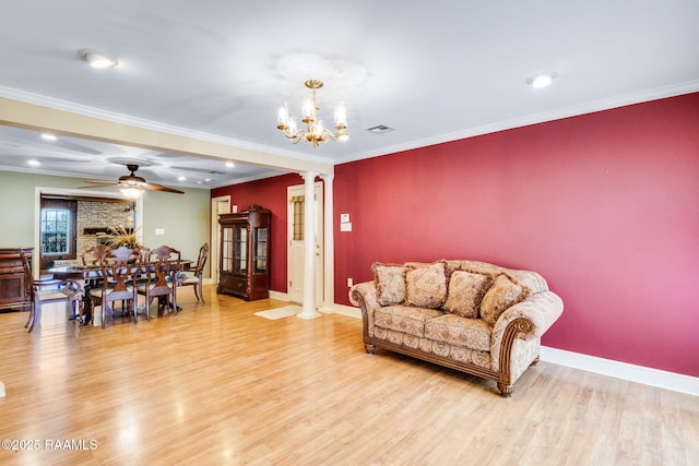 living room featuring decorative columns, wood finished floors, visible vents, and ornamental molding