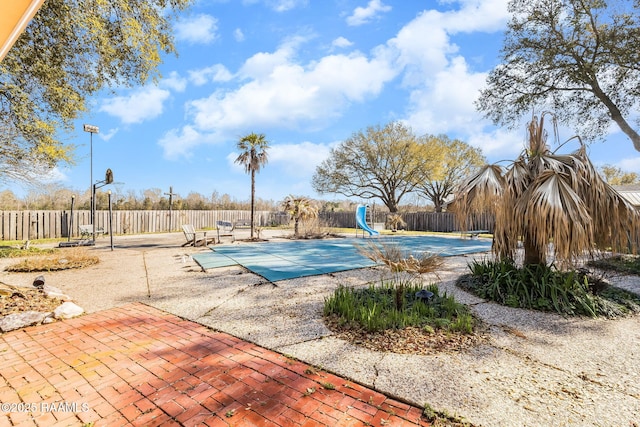 view of pool featuring a patio area, fence, a fenced in pool, and a water slide