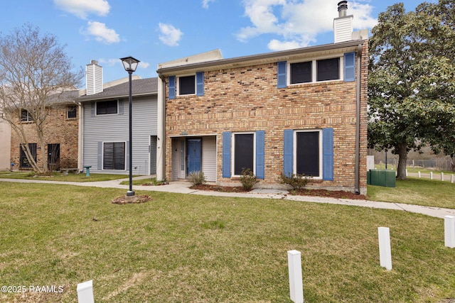 view of front of property with brick siding and a front yard