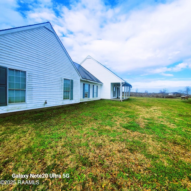 rear view of property with a yard and metal roof