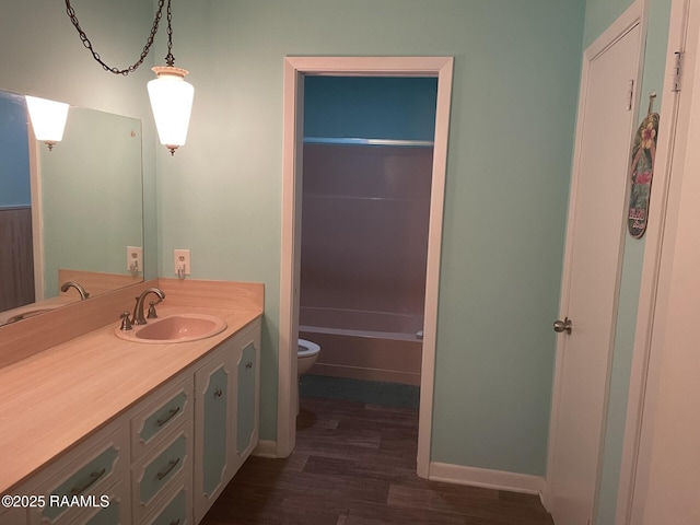 full bath featuring toilet, vanity, baseboards, and wood finished floors