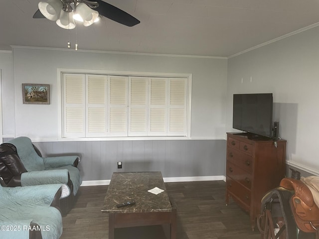 living area featuring ceiling fan, baseboards, wood finished floors, and ornamental molding