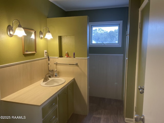 bathroom with vanity, wood finished floors, and wainscoting