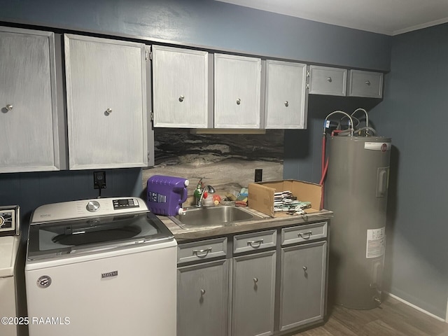 kitchen with wood finished floors, washer / dryer, electric water heater, and a sink