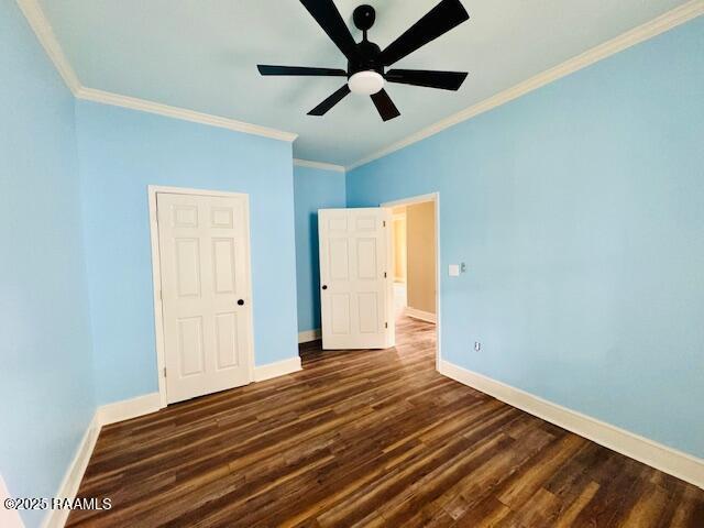 224 W Cherry St, Opelousas, LA 70570 - unfurnished bedroom with ornamental molding, baseboards, a ceiling fan, and dark wood finished floors