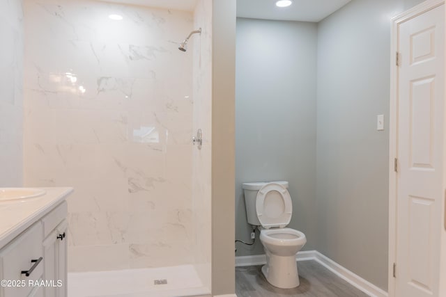 bathroom featuring baseboards, toilet, a stall shower, and vanity