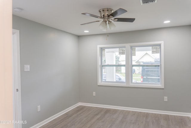 empty room featuring visible vents, ceiling fan, light wood-style flooring, and baseboards