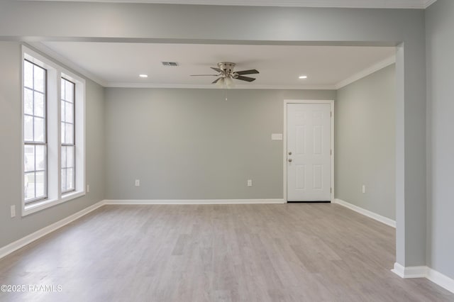 spare room featuring baseboards, light wood finished floors, and ornamental molding